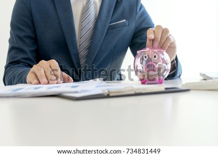Business man hold collect coin in the row in front of the saving box concept economy investment