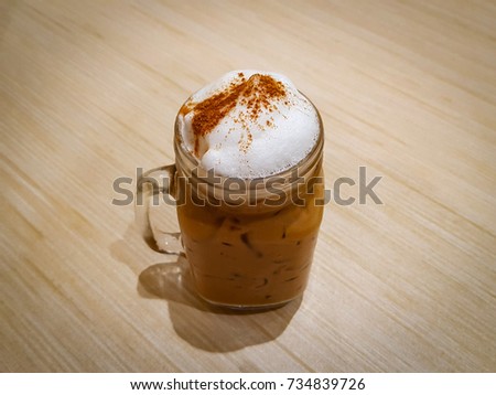 Ice cappuccino in jar on wooden background