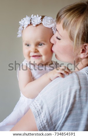happy family. Mother and baby daughter plays, hugging, kissing at hom