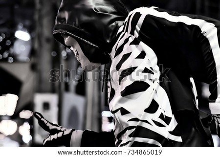 Man in skeleton costume on the walking street in Thailand. This image was blurred or selective focus. Black and white picture.