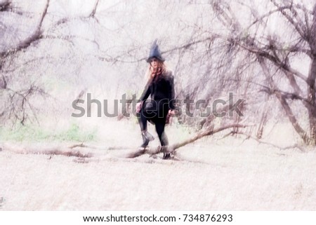 Halloween. Witch in the woods among clumsy trees.