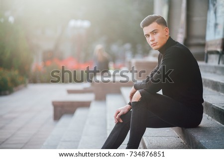 man in black clothes sitting on the stairs, men's look fashion