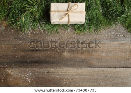 Christmas card on wooden background with snow fir tree and pift box. View with copy space