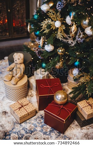 Vertical picture of decorated Christmas tree with balls and many presents under fir tree. Pleasant moments and festive event. Composition of pile with gifts. New Year`s holidays.