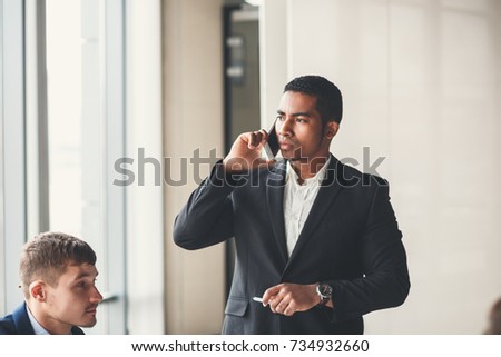 handsome african american businessman using smart phone emailing