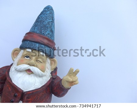 Funny garden dwarf makes peace sign in front of white background
