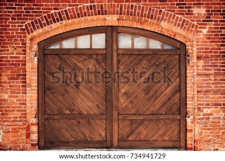 Old Brick Wall with Arch and Wooden Door.