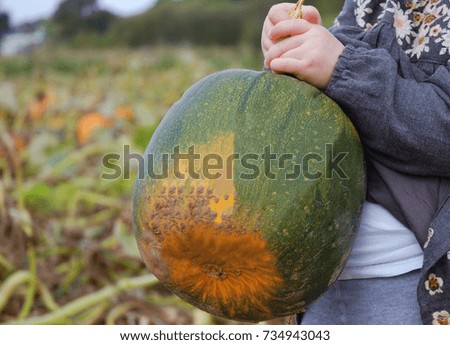 Girl carrying a pumpkin.