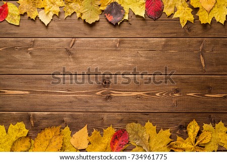 Autumn leaves on dark wooden background. Top view with copy space.