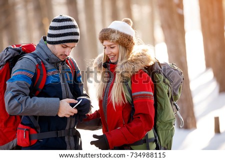 Young hikers in nature looking on cell phone