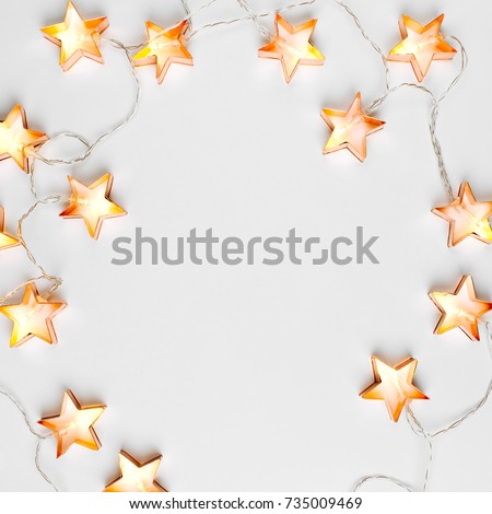 Star shaped Christmas lights frame. Flat lay, top view  Royalty-Free Stock Photo #735009469