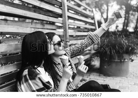 Two pretty brunette girls making selfie outdoor