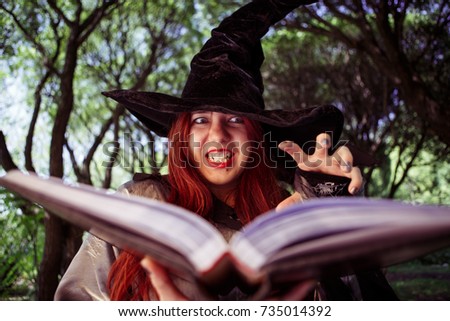 Photo of sinister witch with book of spells