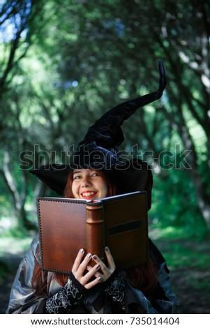Image of smiling witch with magic book