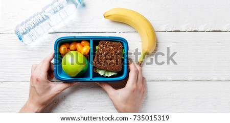 Photo of man's hands with useful lunch in box