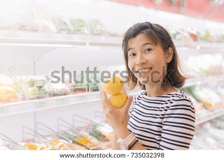 Asian women shopping for lemon fruits and vegetables in supermarkets.