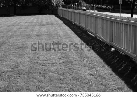 White picket fence in an urban park (Calgary, Alberta, Canada) Monochrome