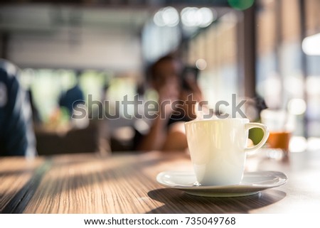Coffee cup on table with hot stream or smoke in cafe