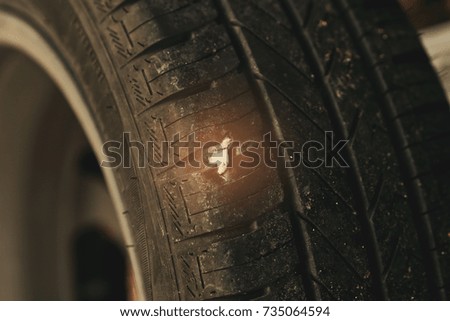 closeup flat tire by rock