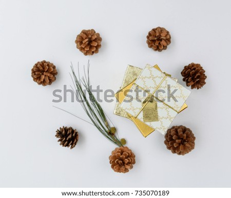 Christmas ornament golden gift boxes set and pine cones fresh green branch on white background,flat lay
