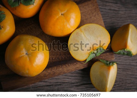 Ripe persimmon on wood cutting board