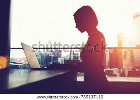 Silhouette of anonymous person using laptop comer and social networks Royalty-Free Stock Photo #735137110