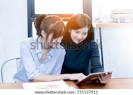 Lifestyle image of best friend girls using tablet shopping online. Cheerful, joyful, happy girl friends checking financial information from tablet. Attractive businesswomen using tablet at meeting.