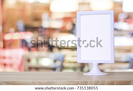Blank white menu board standing on wood table over blur restaurant with bokeh background, space for text, mock up, product display montage, banner