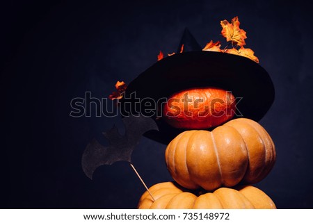 autumn holiday, a large pumpkin, golden leaves on a black witch hat. Halloween, a mesmerizing picture
