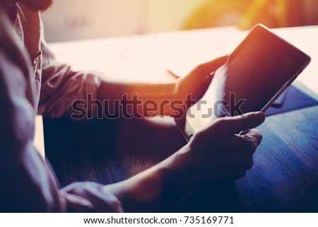 Cropped shot view of freelancer man holding touch pad with copy space screen for text message or advertising, prosperous worker using digital tablet for distance job while sitting in modern interior