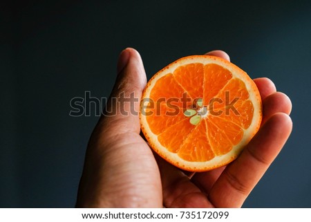Close focus of hand holding sweet orange cut off with copy space for text or advertising