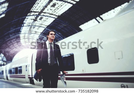 Confident businessman dressed in formal suit walking on railway station platform going to work. Male entrepreneur using public transport