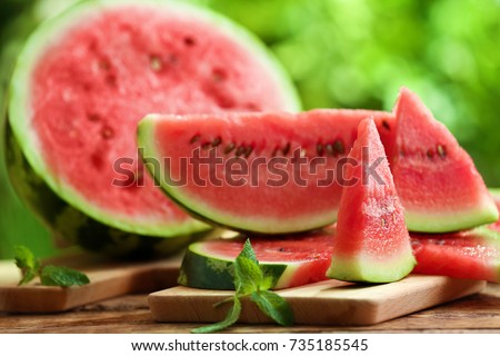 Tasty sliced watermelon on table outdoors Royalty-Free Stock Photo #735185545