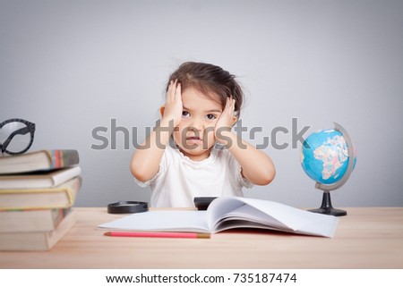 little cute girl suffering from headache while doing overwork with learning , homework , study and exam. school children education habit and parent concern concept. Royalty-Free Stock Photo #735187474