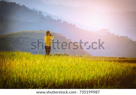 Photographer taking photo of Rice fields on terraced with wooden pavilion at sunrise in Mu Cang Chai, YenBai, Vietnam.