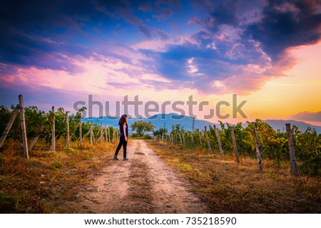 Young girl walking in vineyards in Bulgaria to the sunset