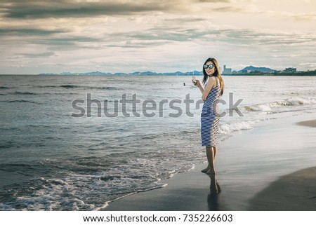 woman traveler take photo the beach by camera phone.