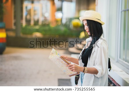 Beautiful Asian woman looking at the map to reach the goal, while tourism in foreign countries