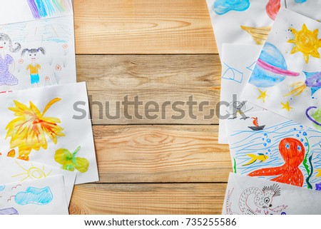 Children's drawings on wooden background
