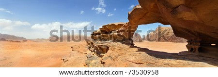 natural rock bridge and panoramic view of Wadi Rum desert, Jordan Royalty-Free Stock Photo #73530958