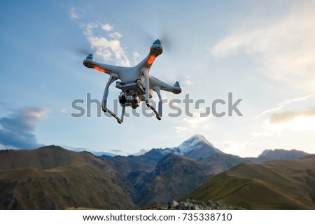 drone copter flying with digital camera in mountains Royalty-Free Stock Photo #735338710