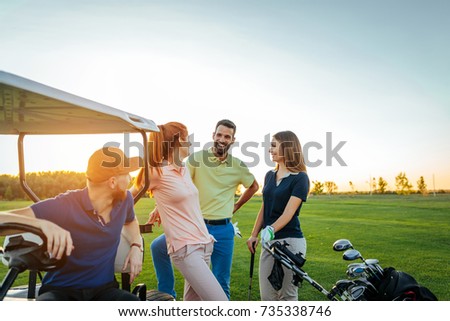 Two young couples enjoying time on a golf course.