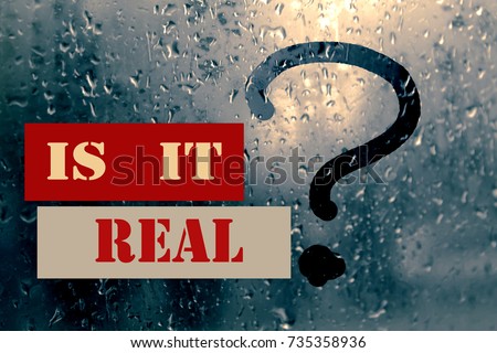 Drops of rain on the misted glass with a question mark; rhetorical question "is it real?". Toned Royalty-Free Stock Photo #735358936