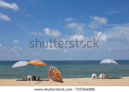 Colorful beach umbrellas fall in the sun by the sand. 