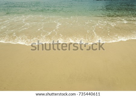  wave of blue ocean on sandy beach.