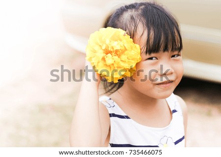 Very cute girl with yellow flowers playing cheerfully.