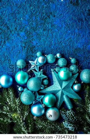New year decoration. Christmas balls and stars with spruce branches on blue background top view mock up