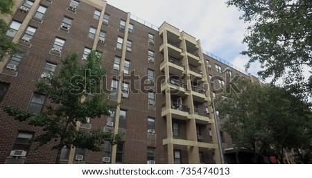 Day time exterior typical NYC urban style apartment building. Balcony window overlook street