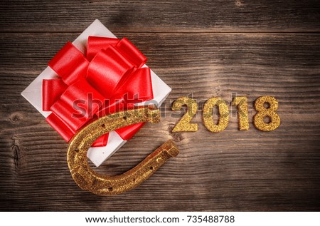 2018 New Year concept. Gold numbers, gift and horseshoe on the wooden background