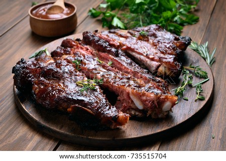 Grilled sliced barbecue pork ribs on wooden board Royalty-Free Stock Photo #735515704